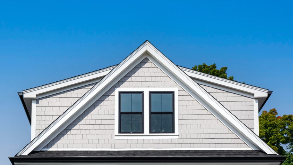 Modern gable roof with light gray shake siding on family home
