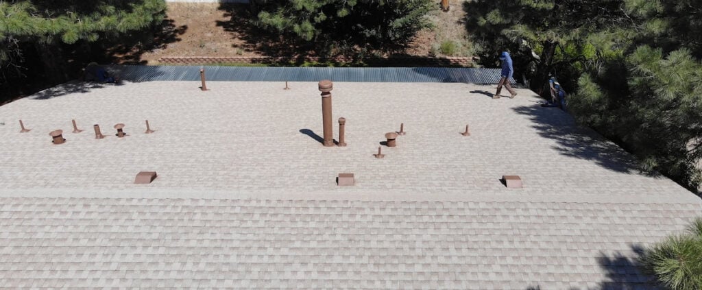 Aerial view of a light shingle roof with multiple vent pipes near Albuquerque