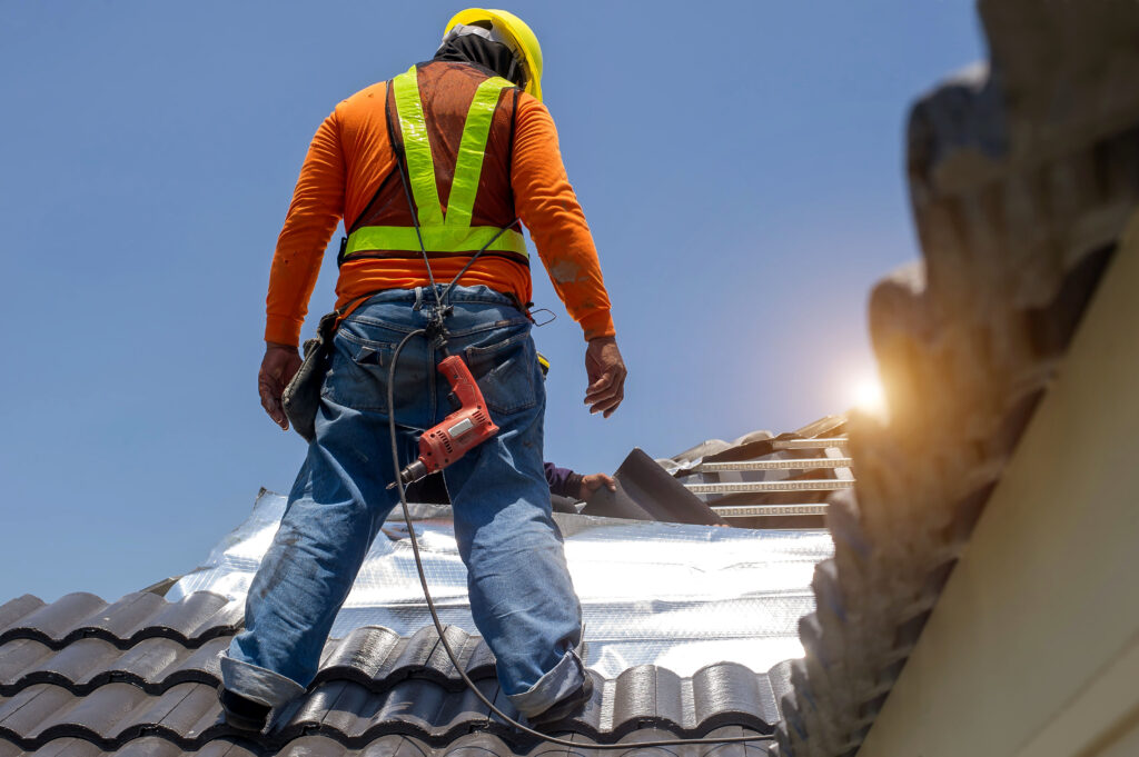worker repairing roof during winter time
